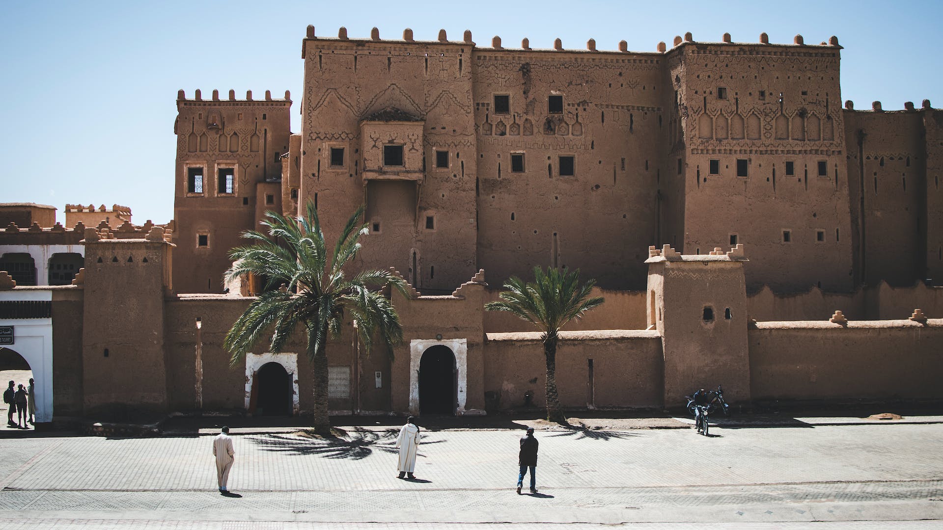 Exterior view of Kasbah Taourirt in Ouarzazate, Morocco. The ancient fortress displays traditional Moroccan clay architecture with intricate designs, serving as a historic site and tourist attraction